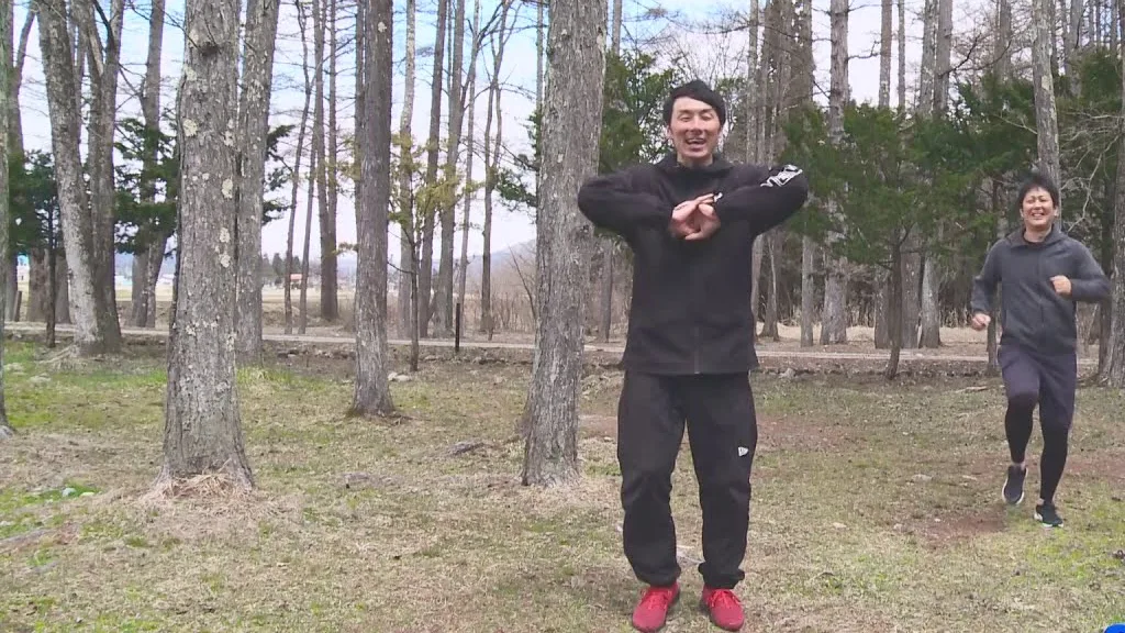 林の中で音楽に合わせて全身運動をする工藤晶。白馬村ケーブルテレビ「リズムに乗ってトレーニング」より